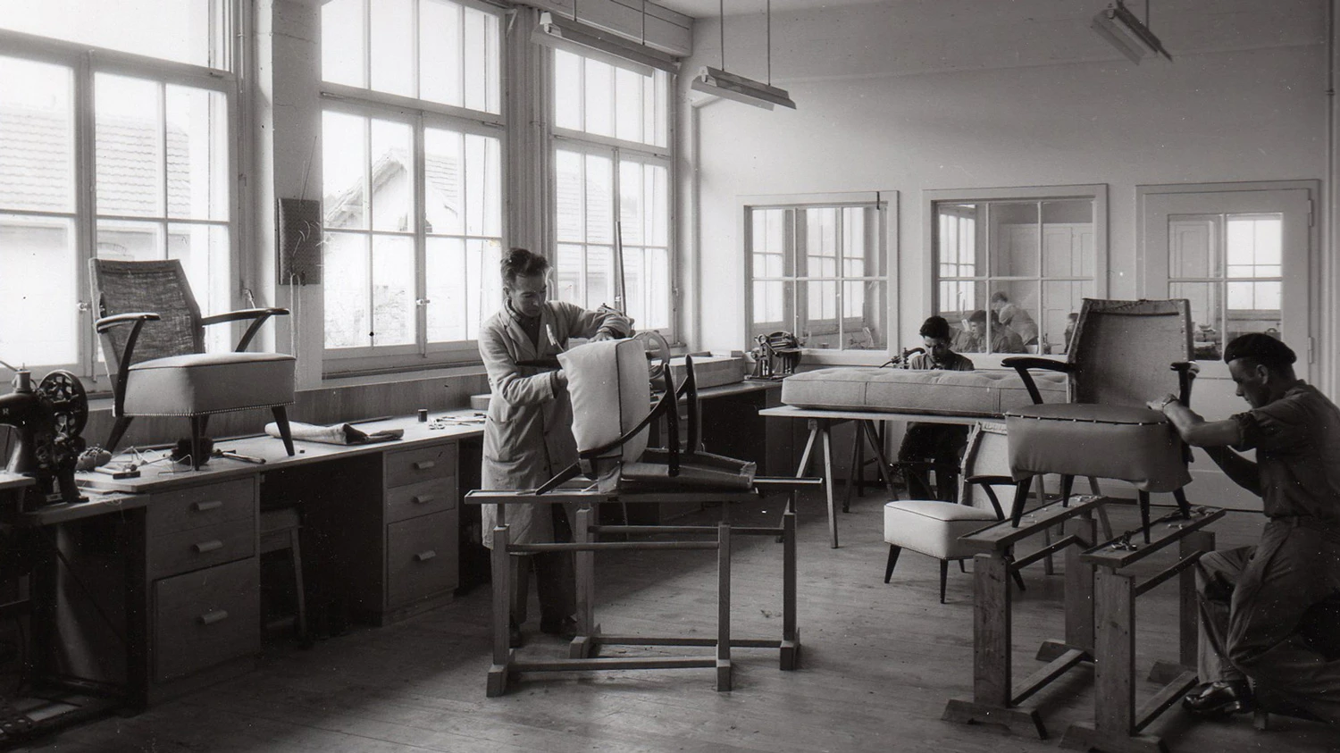 Schwarz-weißes Archivfoto von Jugendlichen, die in einem Atelier arbeiten.