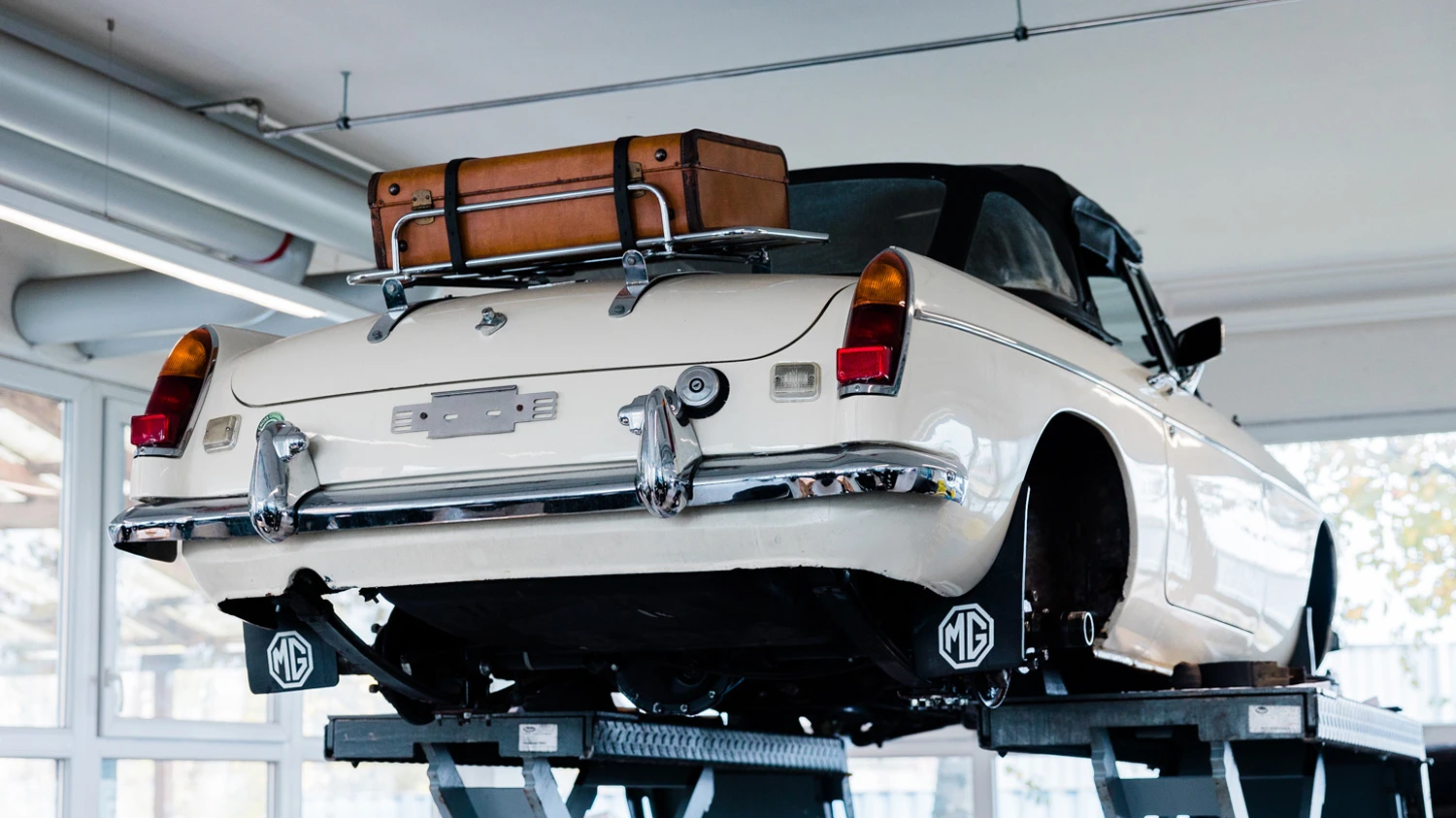 Hochgestelltes Oldtimer-Auto in einer Garage.